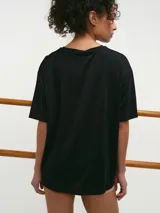 Remera deportiva blanca de manga corta, cuello redondo y corte oversized con tecnología dry fit.