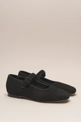 Zapato plano estilo Mary Jane de cuero negro, con punta fina y tira ajustable con hebilla sobre el empeine.
