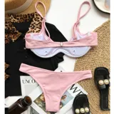 Conjunto de bikini rosa con textura acanalada, compuesto por un corpiño con breteles finos y una bombacha de corte clásico.