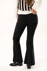 Pantalón de vestir negro de corte acampanado, con cintura de tiro medio, cierre frontal con botón y bolsillos laterales.