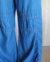 Pantalón de algodón color arena, de corte recto y holgado, con cintura elástica y detalle de costuras horizontales decorativas en la parte inferior de las piernas.