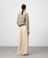 Jersey de punto jacquard con estampado abstracto marmoleado en tonos marrón y blanco. Presenta cuello en V, manga larga y terminaciones en canalé en puños y bajo. Confeccionado en una mezcla de viscosa, mohair y poliamida que ofrece un tacto suave y ligero.