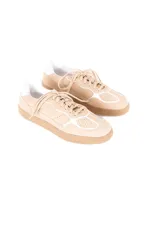 Championes de estilo urbano con diseño inspirado en el calzado deportivo vintage. Están confeccionados en una combinación de cuero vacuno y gamuza en tonos neutros, con suela plana de goma en color caramelo y detalles en blanco.