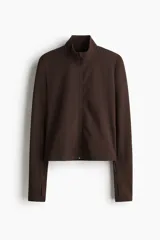 Campera deportiva marrón con cierre frontal y cuello alto, confeccionada en tejido SoftMove. Cuenta con mangas largas que incluyen abertura para el pulgar.