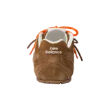 Championes de diseño exclusivo New Balance x Miu Miu modelo 530, confeccionados completamente en gamuza color marrón, con cordones naranjas y detalles blancos en el interior.