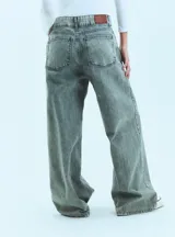 Jean de corte oversize con tiro medio-alto, confeccionado en denim de algodón con lavado tipo ice wash en tono grisáceo. Presenta diseño de cinco bolsillos, cierre frontal y etiqueta de cuero en la parte posterior de la cintura.