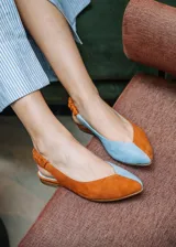 Ballerinas destalonadas de gamuza color camel, con suela plana, puntera redondeada y tira elástica fruncida en el talón. Interior de cuero en color celeste.