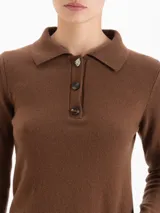 Sweater de punto gris con cuello polo y cierre frontal de tres botones, de manga larga y corte recto.