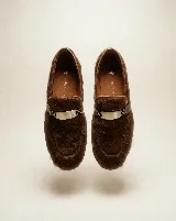 Mocasín de cuero con pelo natural en color marrón, con detalle de herraje metálico en el empeine.