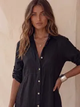 Vestido camisero midi blanco de lino, con cuello camisero, botonadura frontal completa con botones de nácar, mangas largas con tira para arremangar y abertura lateral en el bajo.