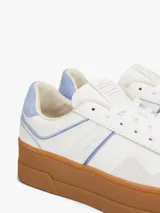 Zapatillas de corte bajo inspiradas en el baloncesto, con exterior de piel blanca, detalles en azul claro y suela de plataforma color caramelo. Presentan paneles de texturas a contraste y logo de la marca en el lateral.