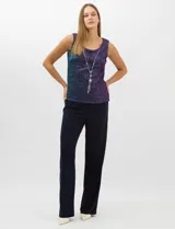 Conjunto de tres piezas compuesto por una musculosa recta, un cardigan liviano de frente abierto con mangas 3/4 y un pantalón de seda fría. La musculosa y el cardigan están confeccionados en tejido plisado con hilos metalizados tornasolados. Incluye collar removible y forro interno a tono.