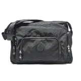Cartera tipo bandolera de tela técnica color negro, con múltiples compartimentos frontales con cierre, correa ajustable con logo estampado y aplique circular con logo de la marca.