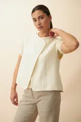 Chaleco color beige con textura tipo espiga, corte holgado y solapa cruzada.