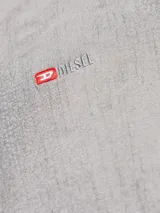 Remera de manga corta Diesel con cuello redondo y diseño de efecto craquelado en tono rosado.