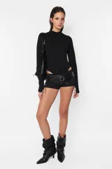 Body negro de algodón con lycra, de corte ajustado, manga larga con detalle de mitón en los puños y cuello media polera. Cierre con botones a presión en la entrepierna.