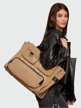 Bolso tipo tote Marc Jacobs modelo The Cargo Canvas Large Tote Bag, color tostado, confeccionado en lona con múltiples bolsillos delanteros con solapa y cierre, detalle de anilla metálica y estampado gráfico con el nombre de la marca. Cuenta con asas dobles para el hombro.