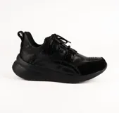 Championes urbanos de diseño artesanal, color negro, con combinación de texturas que incluyen acabado tipo croco y detalles perforados en la puntera. Presenta suela de plataforma ergonómica y cierre mediante cordones.