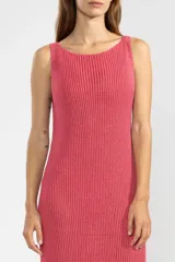 Vestido largo tejido en jersey fucsia, con escote redondo y abertura lateral.