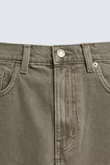 Bermuda de denim de algodón, color verde claro lavado, de corte recto y tiro medio. Presenta cinco bolsillos y cierre frontal con cremallera y botón.