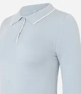 Blusa de punto color blanco con cuello polo, manga larga y detalles de ribete en contraste color negro en el cuello, puños y ruedo. Confeccionada en mezcla de viscosa, poliéster y poliamida.