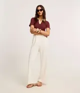 Blusa acanalada color borgoña con cuello polo contrastante en color crema, de mangas cortas y corte ajustado.