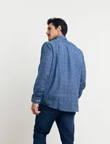 Camisa azul con estampado de lunares blancos, de manga larga y corte clásico.