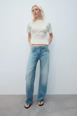 Jeans de tiro bajo y cinco bolsillos, con diseño de pierna ancha y larga, de color celeste con efecto desgastado. Cuenta con detalle de estrella bordada con brillos en el bolsillo delantero.