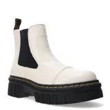 Botas Chelsea de mujer color blanco hueso, caña media, con paneles elásticos laterales negros y puntera reforzada con costura. Poseen una suela plataforma gruesa y dentada de color negro con costura amarilla visible en el borde.