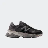 Championes New Balance modelo 9060, color negro y gris oscuro, con superposiciones de gamuza y malla, y una suela sobredimensionada con tecnología de amortiguación.