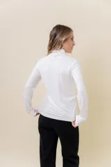 Polera de manga larga con cuello alto, confeccionada en tejido suave y elástico con calce al cuerpo.