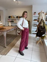 Pantalón de corte recto confeccionado en pana color bordó, con cintura alta y cierre frontal.