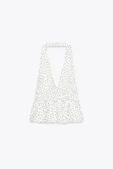 Top blanco con escote halter, espalda descubierta y volado en el ruedo.