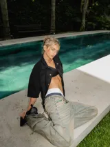 Pantalón de jean de lavado claro (oxido), corte ancho y tiro bajo, con cordones ajustables a la vista en la cintura y bordado en el frente.