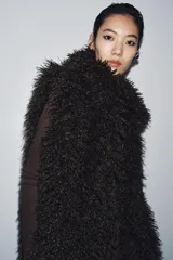 Chaleco de pelo sintético con cuello solapa y diseño sin mangas. Cuenta con forro interior a tono y cierre frontal mediante ganchos metálicos.