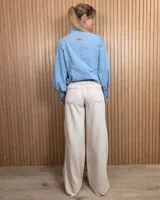 Jean de tiro medio en denim color tostado, con diseño de pierna ancha estilo wide leg y bolsillos traseros.