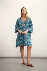 Vestido corto con estampado abstracto en tonos azules y blancos, escote en V con lazo ajustable y mangas 3/4 acampanadas.