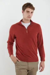 Sweater verde oliva de tejido acrílico con textura similar al cashmere, corte clásico, cuello alto con cierre metálico y tirador de cuerina ecológica.