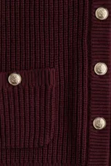 Cárdigan corto de punto acanalado en color vino tinto, con cuello redondo, cierre frontal de botones dorados y bolsillos de parche con botón en la parte delantera.