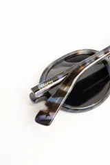 Lentes de sol polarizados con armazón redondo de acetato en color marrón translúcido y micas en tono ámbar.