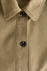 Campera camisera corta de sarga de algodón color verde militar, con cuello camisero, cierre frontal de botones oscuros y dos amplios bolsillos delanteros de parche.