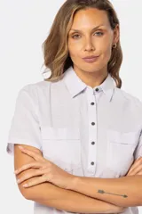 Camisa de manga corta confeccionada en lino y algodón, con cuello camisero, cierre frontal de medio botón y dos bolsillos plaqué con solapa en el pecho.