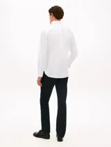Camisa Tommy Hilfiger de corte regular, confeccionada en algodón Oxford elástico y ligero. Presenta cuello con botones, cierre frontal abotonado, mangas largas con puños redondeados y un bolsillo de parche en el pecho con el logo bordado.