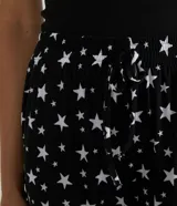Pantalón de pijama negro con estampado de estrellas blancas, cintura elastizada con cordón ajustable y tobillos ajustados.