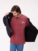 Campera reversible con capucha oculta, confeccionada en sarga de algodón con elastano en el exterior y nylon de poliéster en el interior. Presenta cierre frontal con botones a presión, costuras visibles en contraste y puños elásticos.