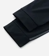 Pantalón deportivo de corte ajustado, confeccionado en tejido de poliéster texturizado color negro. Presenta cintura elástica con cordón de ajuste, bolsillos laterales con cierre y puños elásticos en los tobillos.