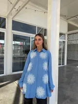 Camisa celeste con estampado de flores blancas, de corte holgado y manga larga.