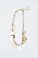 Collar de cordón beige con múltiples dijes colgantes en forma de corazón de acabado metálico dorado y pequeñas cuentas de cristal verde.
