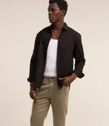 Pantalón de hombre color beige, de corte slim cropped, confeccionado en sarga de algodón, poliéster y elastano.