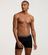 Calzoncillo tipo bóxer para hombre, color negro, confeccionado principalmente en algodón con un pequeño porcentaje de elastano. Presenta una cintura elástica ancha con franjas horizontales en tonos de gris y el texto "LUPO UNDERWEAR" repetido.